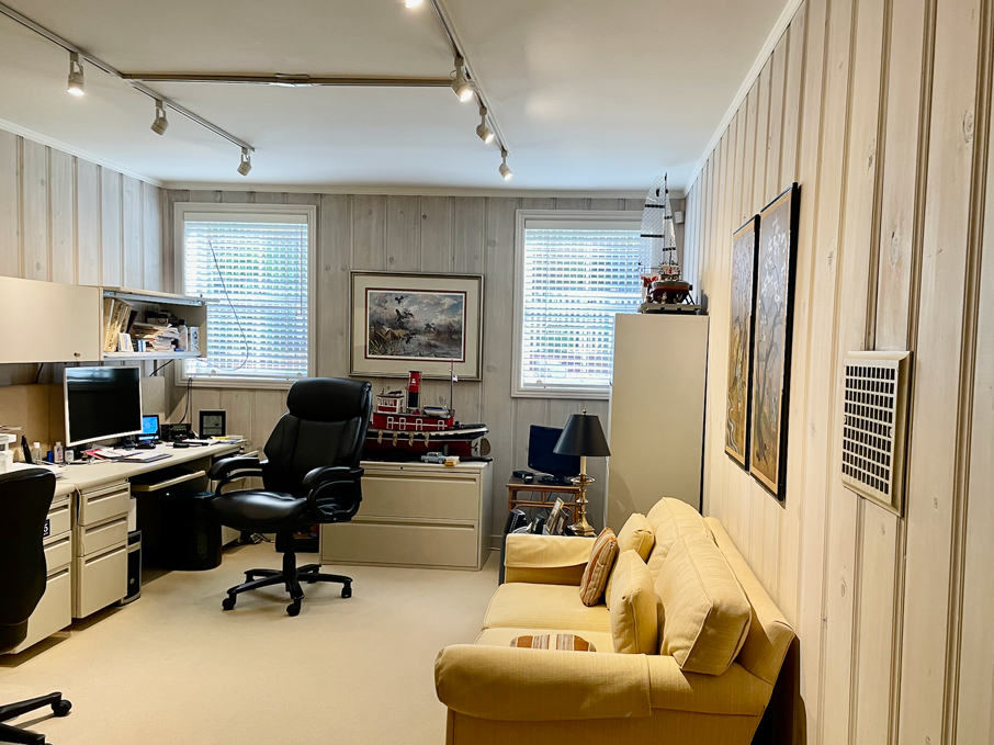 a room with a couch, chair, desk and computer.